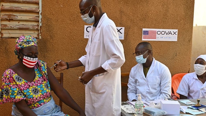 Une mère reçoit sa deuxième dose de la vaccination COVID-19 dans un centre de santé à Obassin, au Burkina Faso