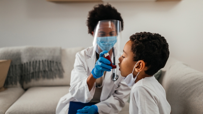 Une médecin aide un petit garçon à utiliser son inhalateur contre l'asthme (photo d'illustration)