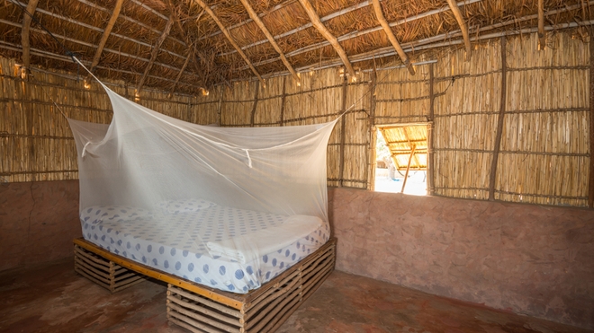 Un lit équipé d'une moustiquaire, dans la petite île de Sipo