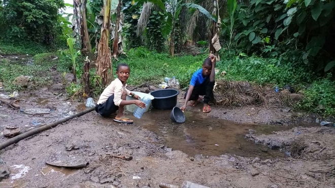 Des enfants du quartier de Bomaka à Buea, dans le sud-ouest du Cameroun, puisent de l'eau à une sourc