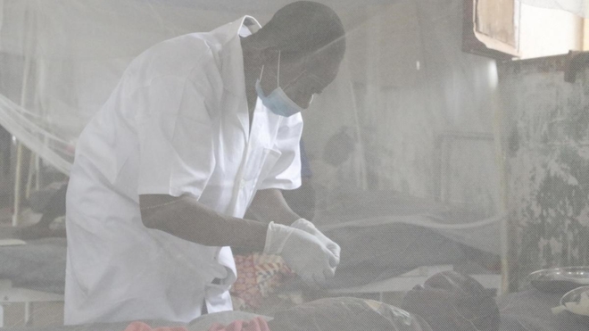 Un infirmier s'occupe d'un jeune patient malade de la rougeole, hôpital général de Bosobolo, en RDC, février 2021