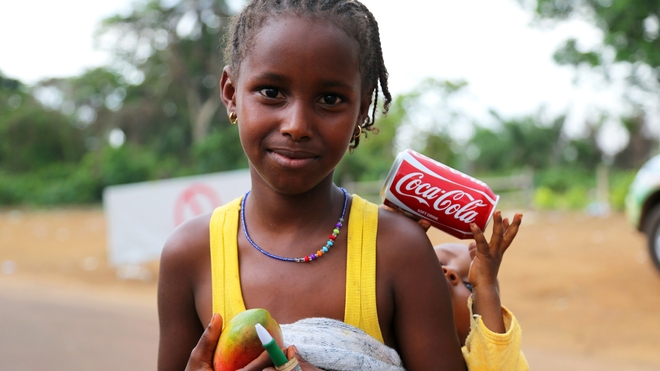 Une fillette à qui l'on donne une canette de Coca-Cola.