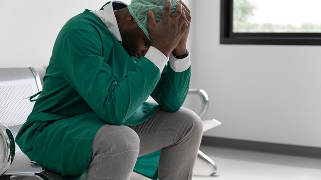 Un médecin se tenant la tête entre les mains (photo d'illustration)