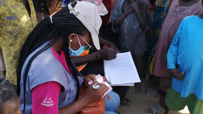 Dr Efouba Gisèle, chef d'unité des activités de vaccination supplémentaire au PEV, remplit le carnet de vaccination d'un enfant vacciné contre la rougeole à l'extrême nord du Cameroun.