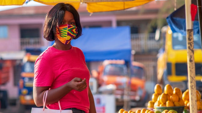 Une femme qui porte un masque dans un marché 