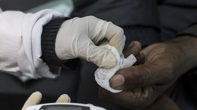 Un agent de santé effectuant un test de dépistage du diabète en Afrique
